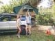 Young women friends having fun in a campsite into the forest. Leisure time and enjoyment concept.